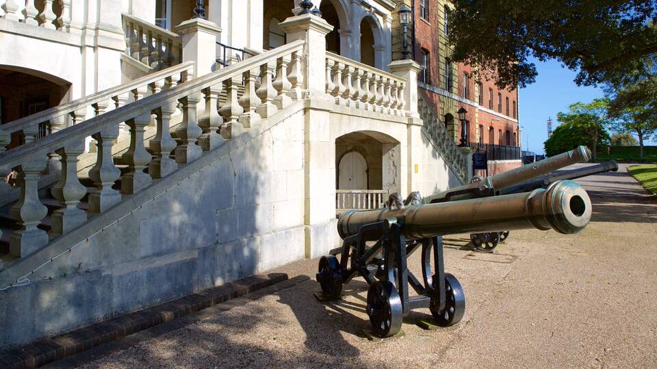 A historic building with a grand staircase and a cannon.
