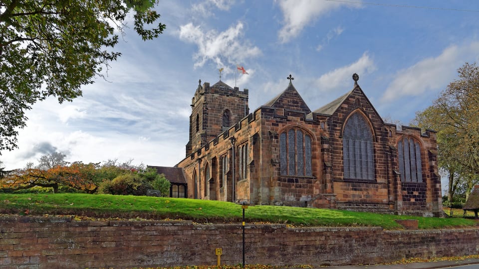 A historic church with a tall tower and large arched windows.