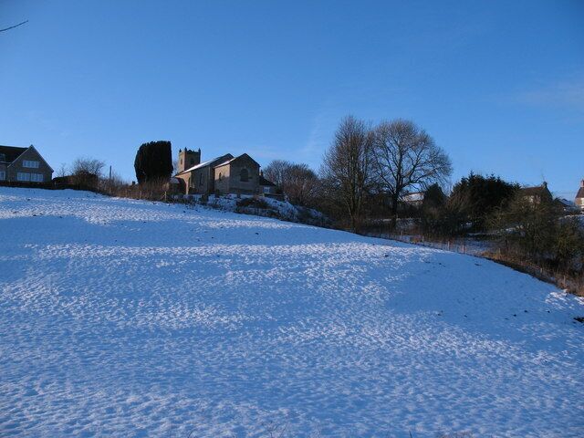 Cold Kirby from the Cleveland Way Snow covered pasture leading up to the village with the church of St Michael at the top of the bank.