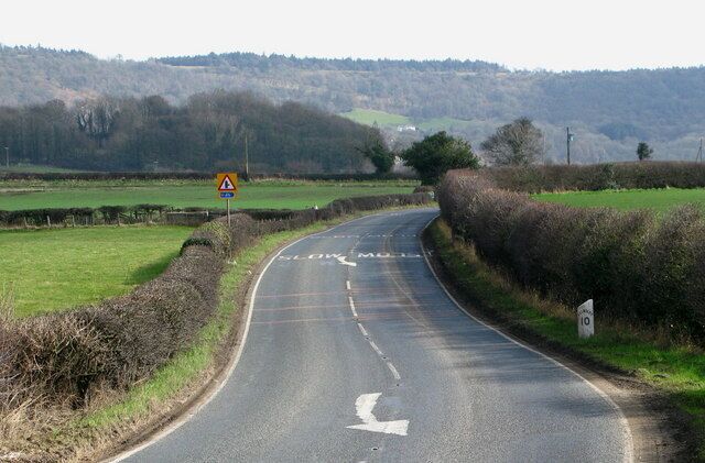 A rural road curving to the right with a warning sign for a junction ahead.
