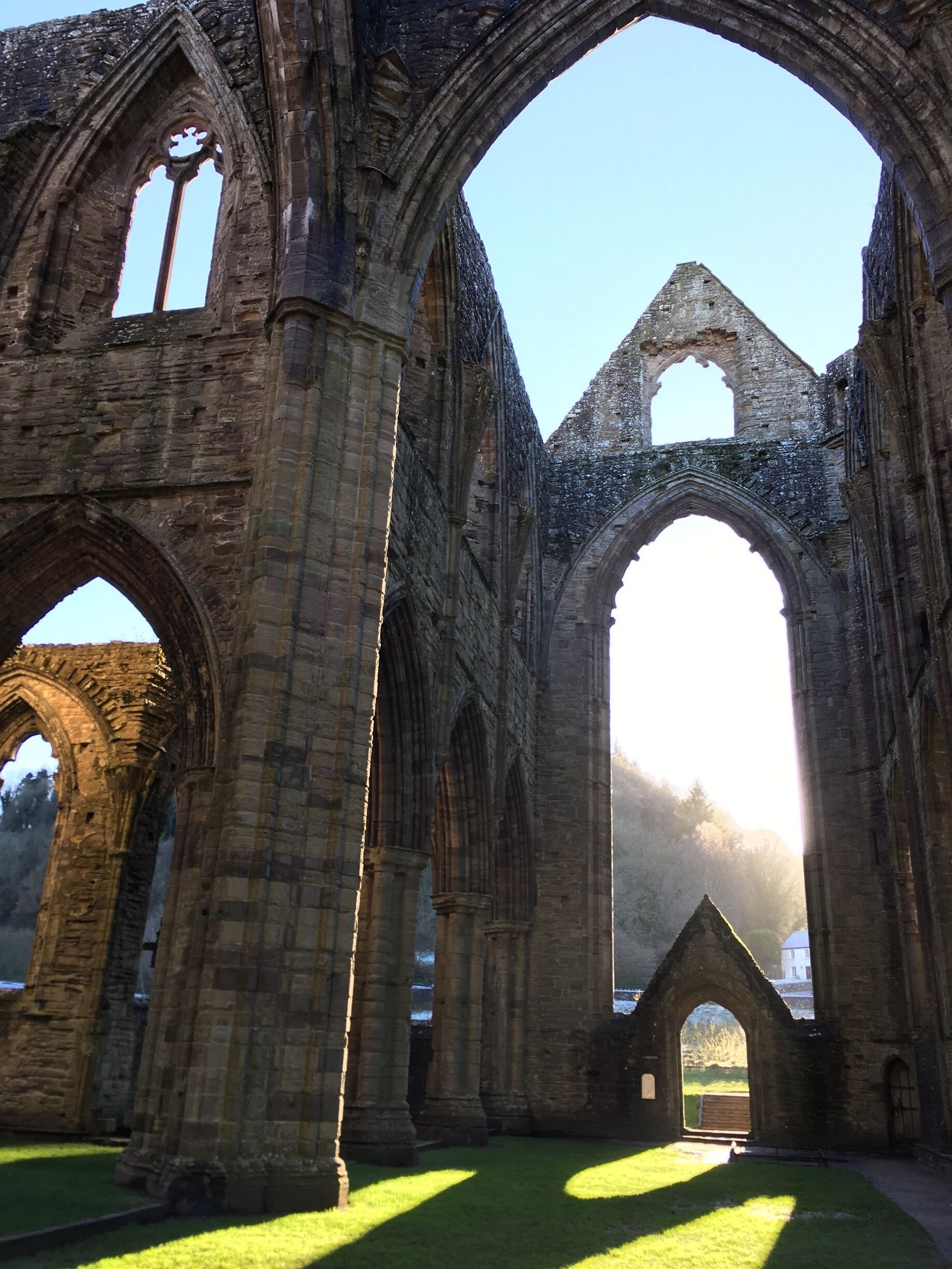An ancient stone structure with large arches and columns, likely a historical building or cathedral.