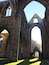 An ancient stone structure with large arches and columns, likely a historical building or cathedral.