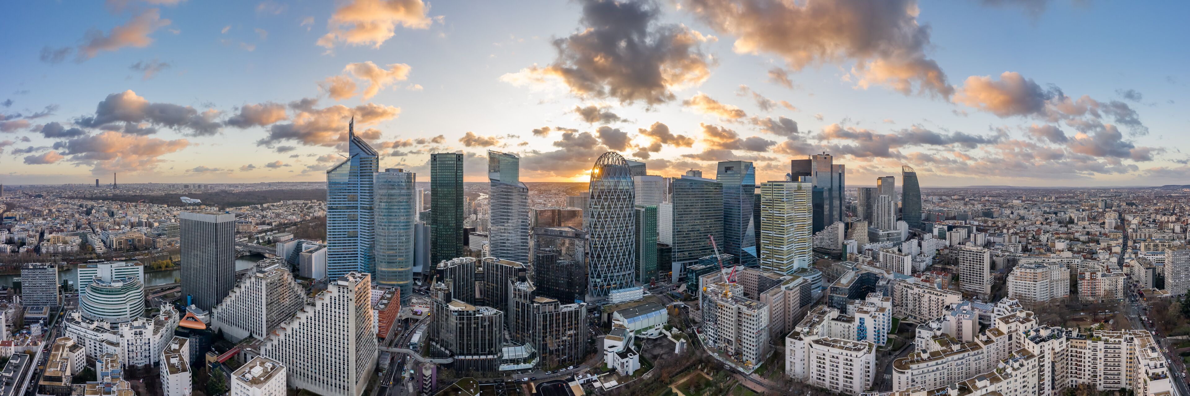 A cityscape with modern skyscrapers and a river in the foreground.