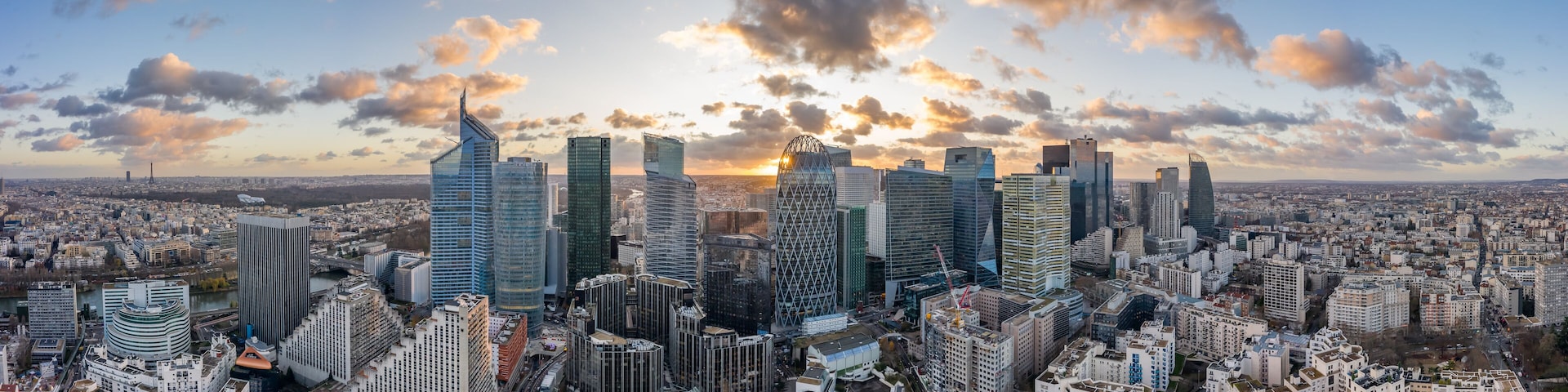 A cityscape with modern skyscrapers and a river in the foreground.