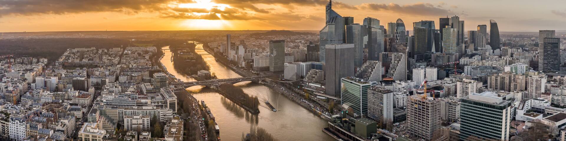 Aerial pano drone shot of La Defense skyscraper complex by la Seine with Pont Neuilly during sunset hour