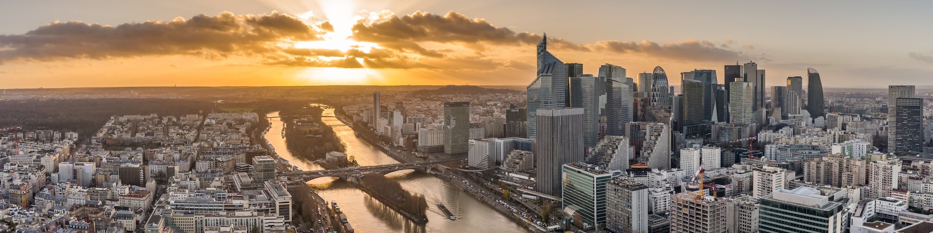 Aerial pano drone shot of La Defense skyscraper complex by la Seine with Pont Neuilly during sunset hour
