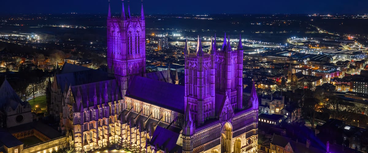 Lincoln Cathedral Lincolnshire at night. Aerial view of the Cathedral illuminated in Purple. Twilight showing Lincoln city centre