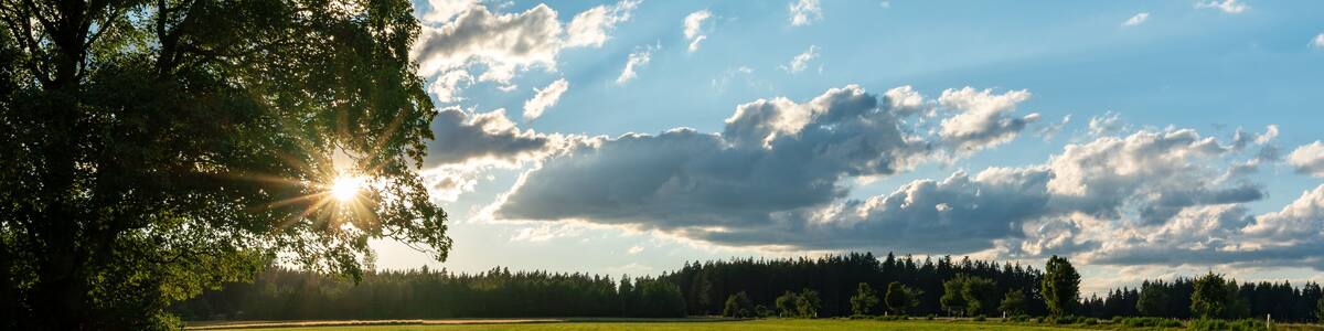 panorama view of evening sun in fields and forests of southern Germany