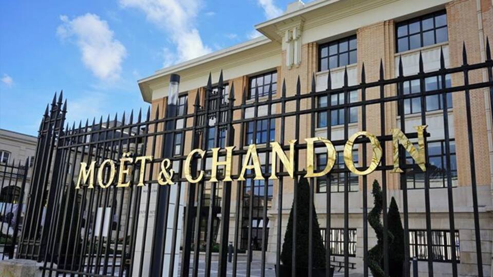 A building with a black iron fence and the words "MOËT & CHANDON" in gold lettering.