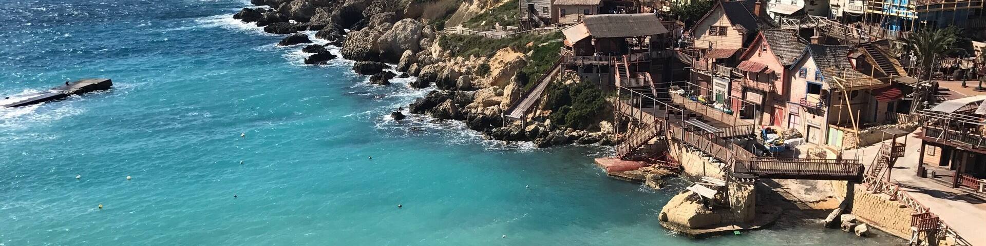 Un pueblo costero con casas construidas sobre acantilados rocosos con vistas a aguas turquesas.