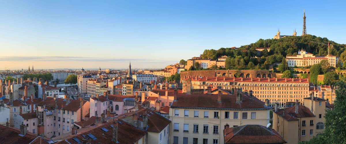 A cityscape with a prominent hilltop church and a tower.