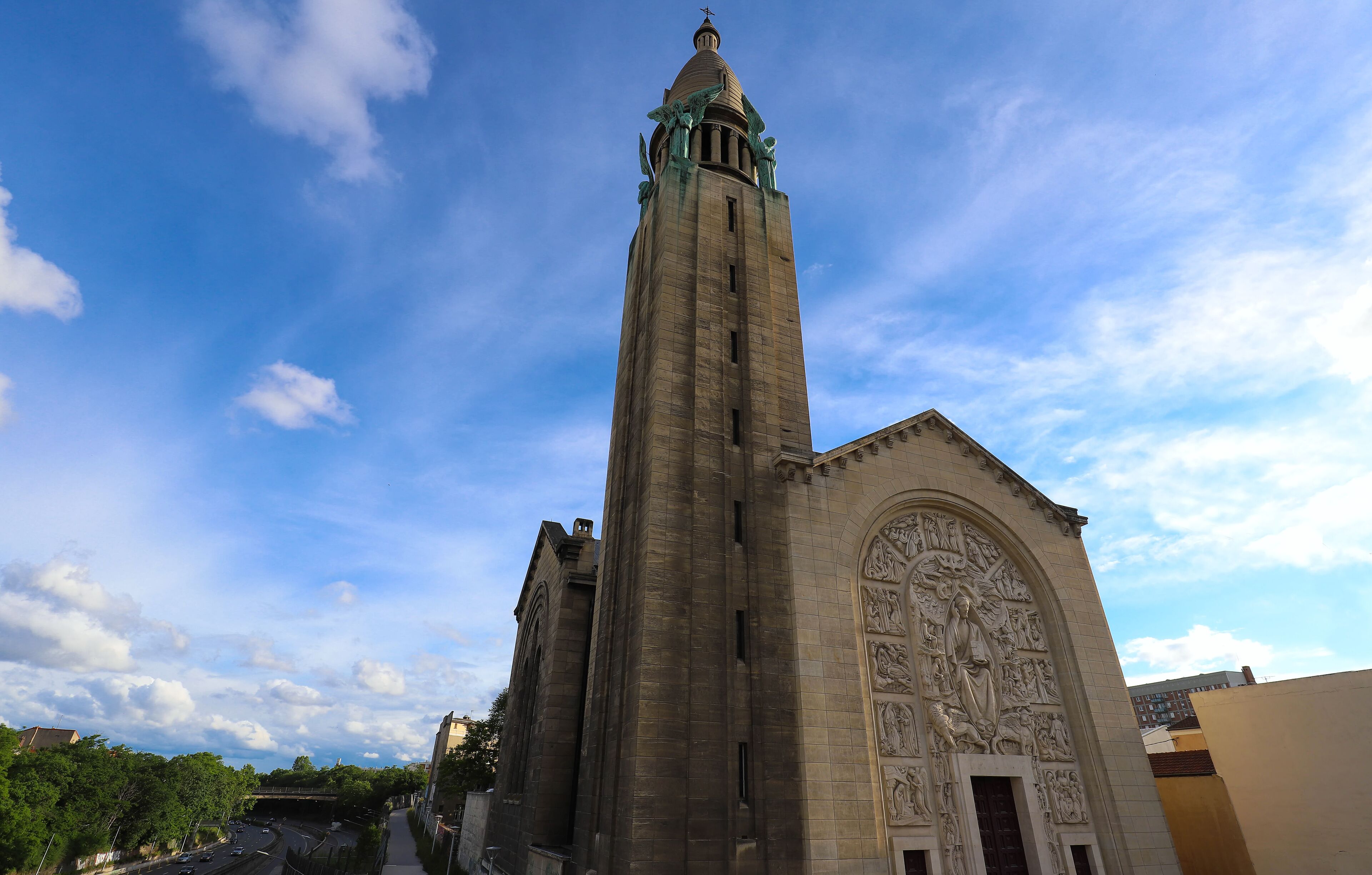 A tall church with detailed sculptures and a spire.