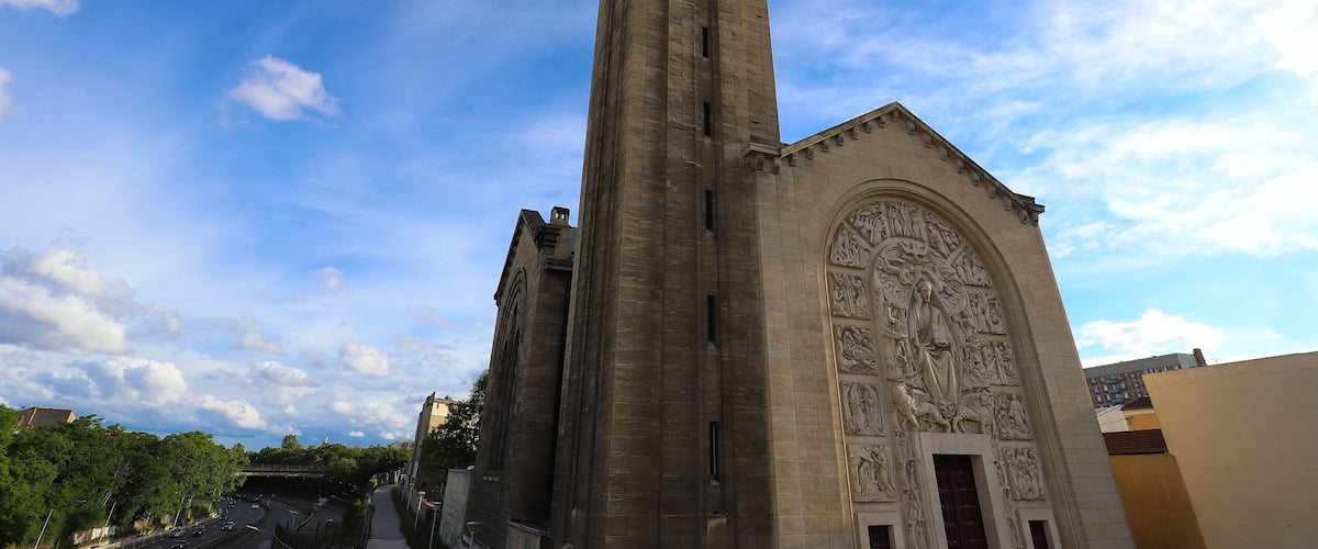 A tall church with detailed sculptures and a spire.