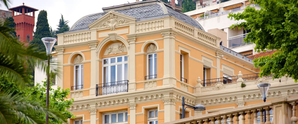 A historic building with ornate architecture, large windows, and a balcony.