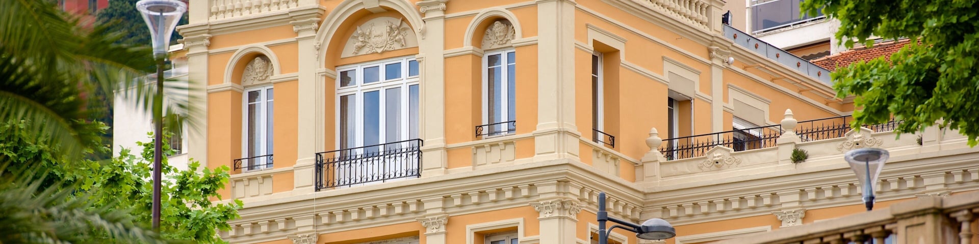 A historic building with ornate architecture, large windows, and a balcony.