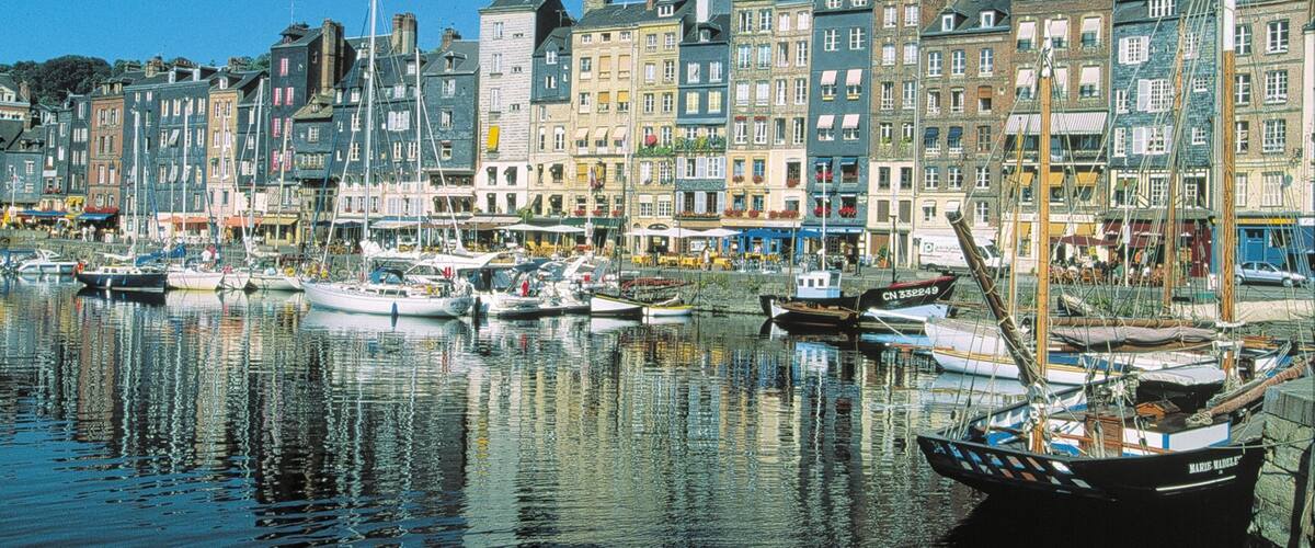 A harbor with boats docked and buildings along the waterfront.