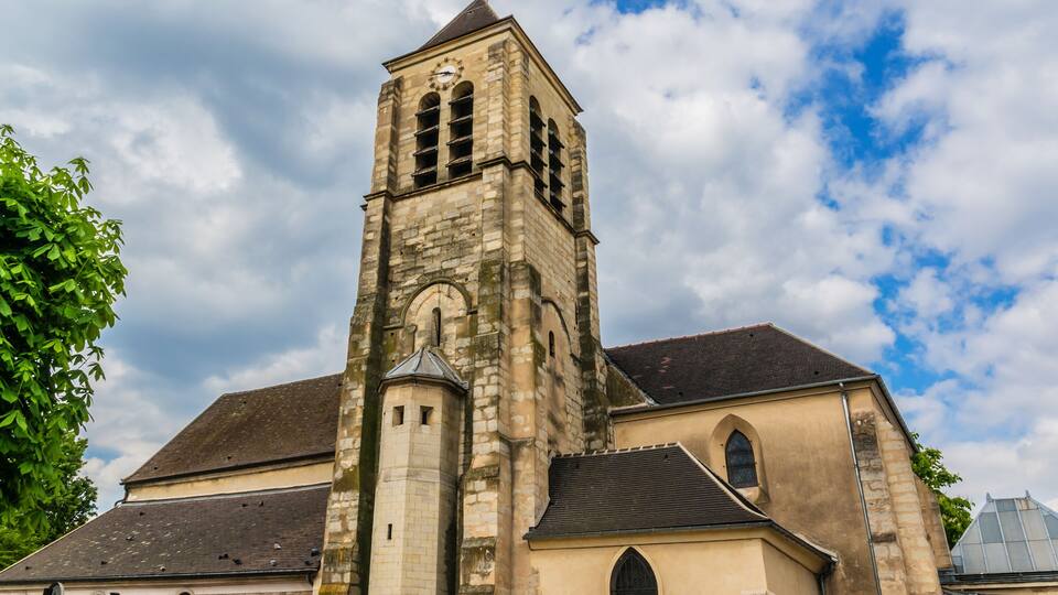 A historic church with a tall bell tower and arched windows.