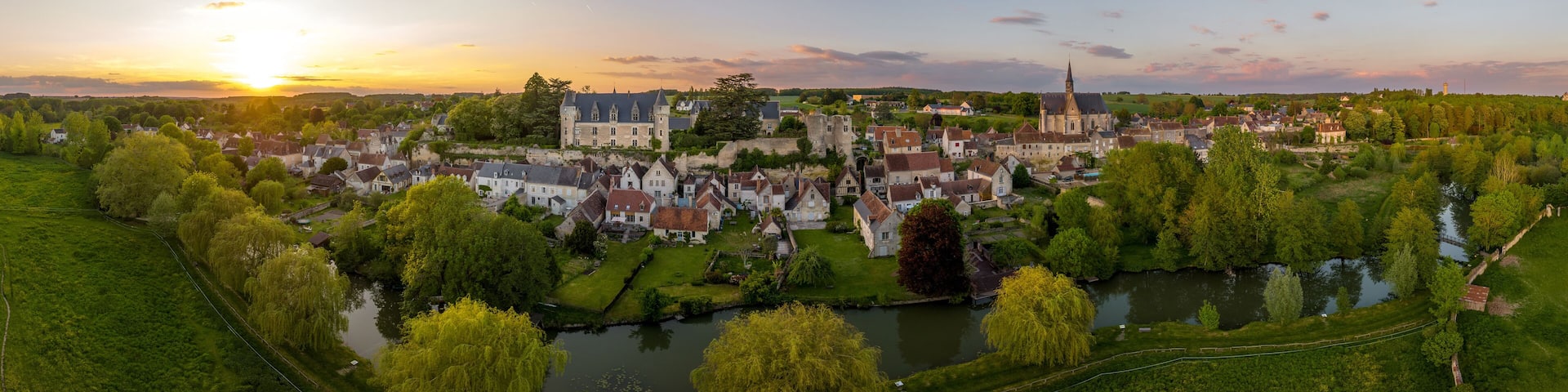 Aerial sunset view of Montresor medieval castle with a Renaissance mansion in Indre et Loire, on a rocky overhand dominating the valley, on of the most beautiful villages of France