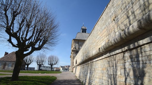 Un mur de pierre, un sentier et des arbres sans feuilles.