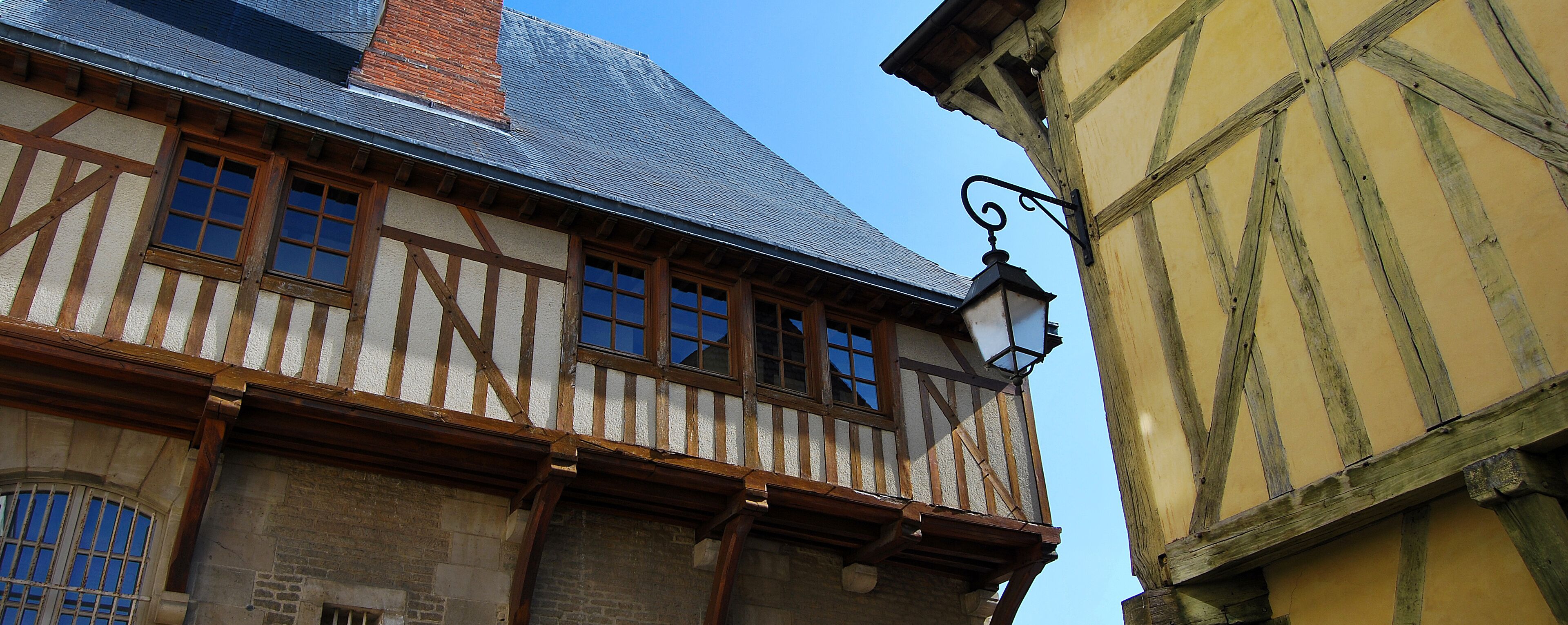 A half-timbered building with a steeply pitched roof and a visible brick chimney.