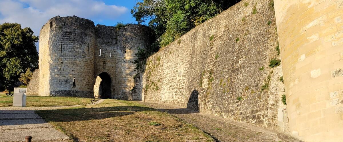 A stone castle with a large archway and a paved pathway.