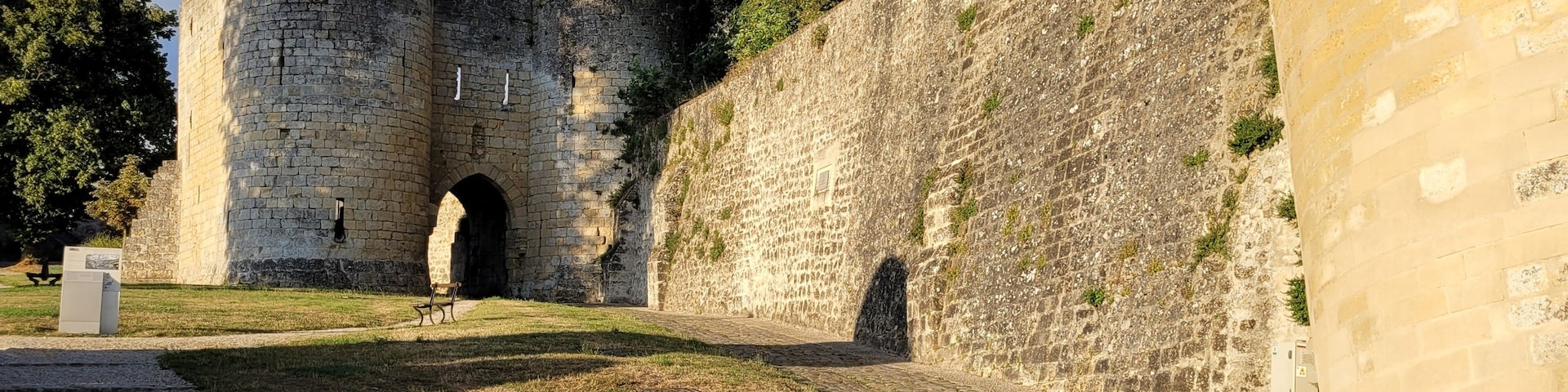 A stone castle with a large archway and a paved pathway.