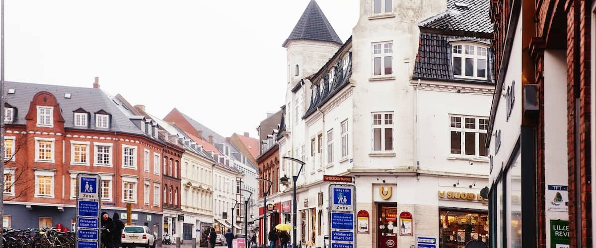 A street with historic buildings, including a tower with a conical roof.