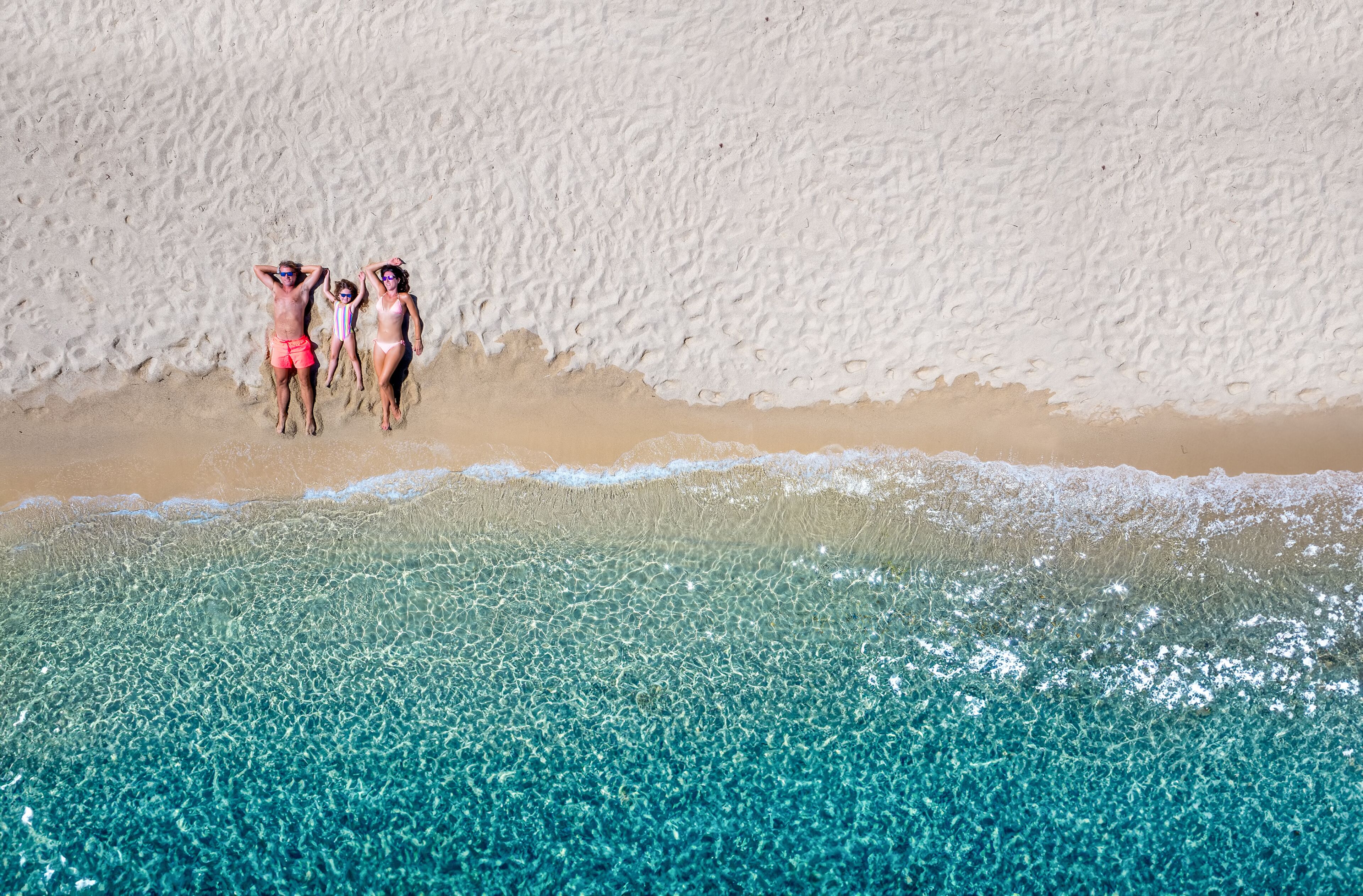 A beach with clear turquoise water and a sandy shore.