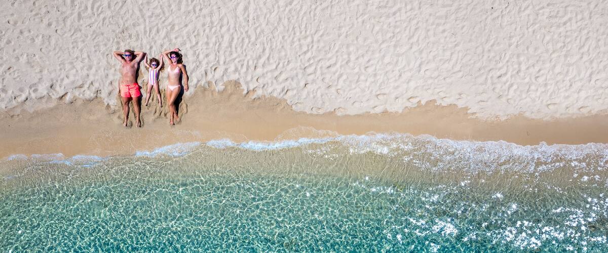 A beach with clear turquoise water and a sandy shore.