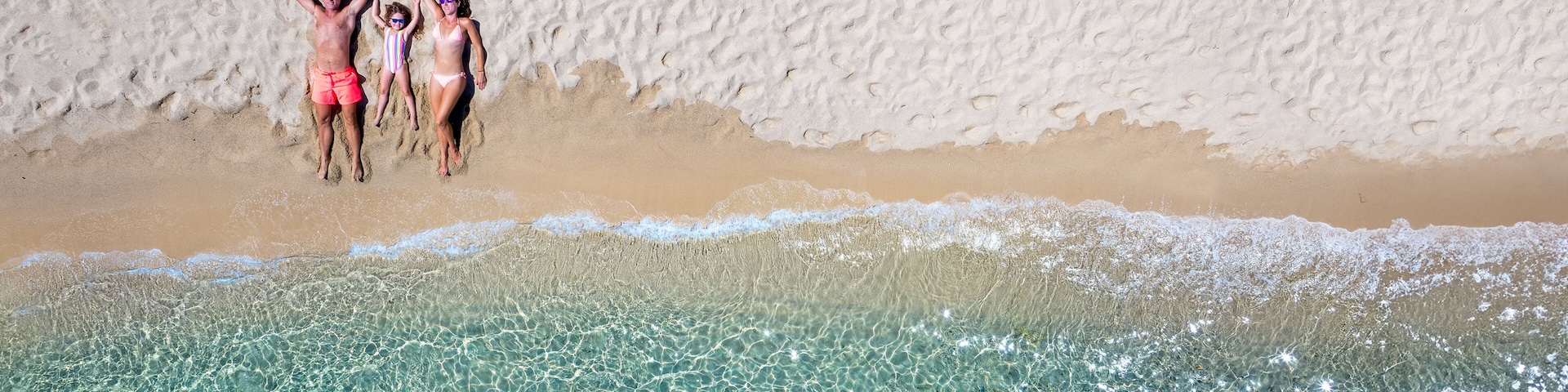A beach with clear turquoise water and a sandy shore.