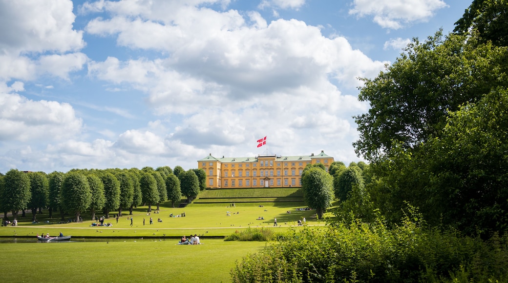 People relaxing on the lawn in front of Frederiksberg Palace in Copenhagen Denmark on warm summer day