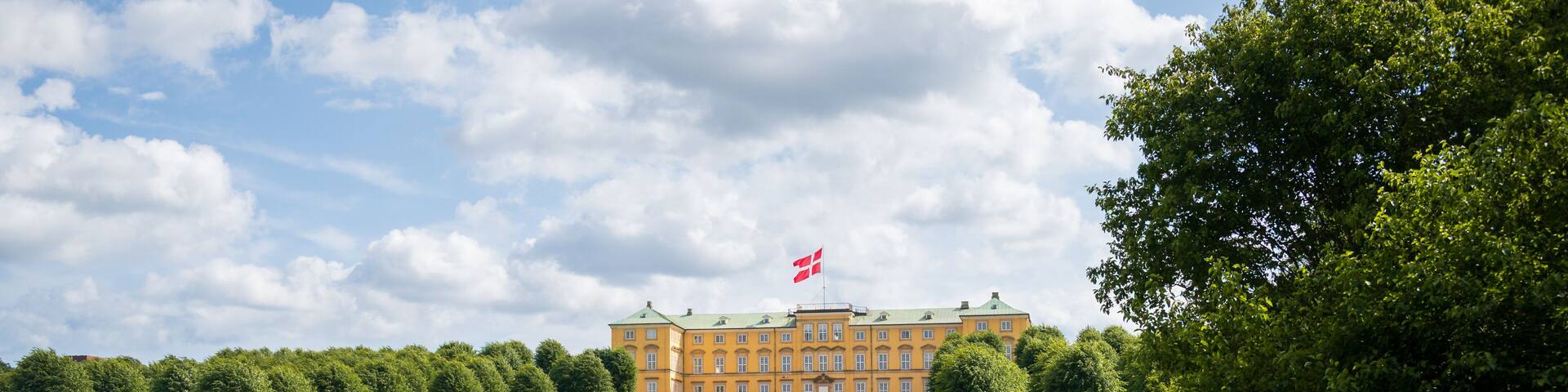 People relaxing on the lawn in front of Frederiksberg Palace in Copenhagen Denmark on warm summer day