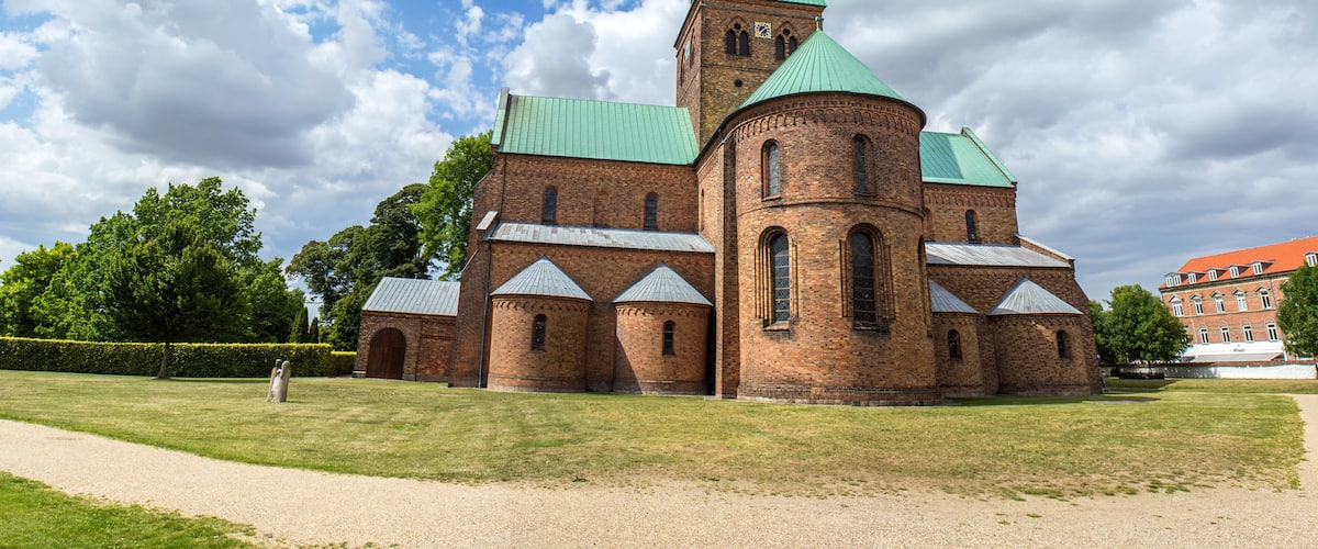 A historic church with a green spire and brick architecture.