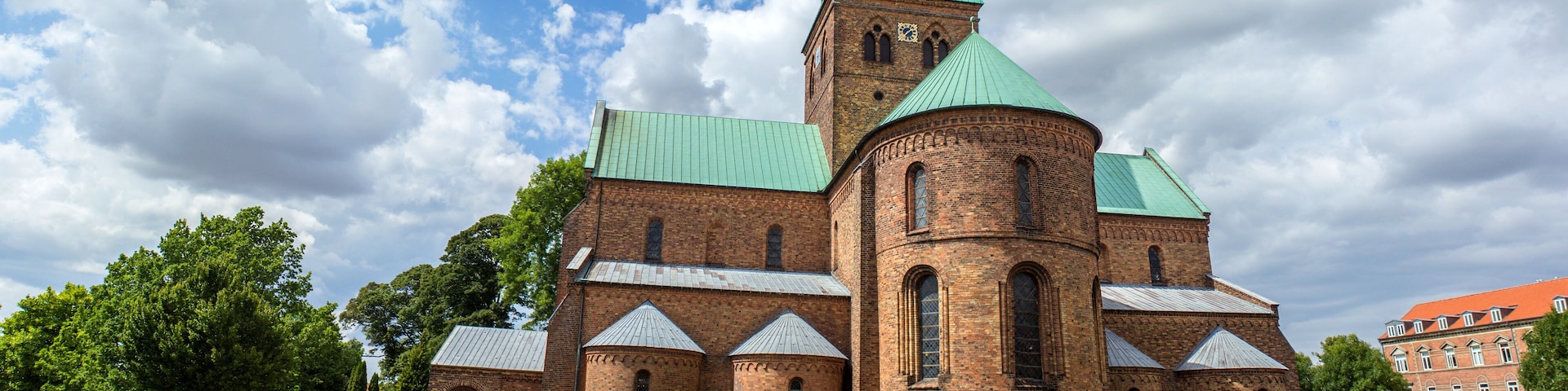 Eine historische Kirche mit einem grünen Turmspitze und Backsteinfassade.