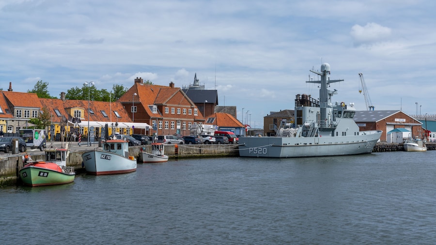 the harbor and port of Koge with colorful boats and a warship from the Danish navy