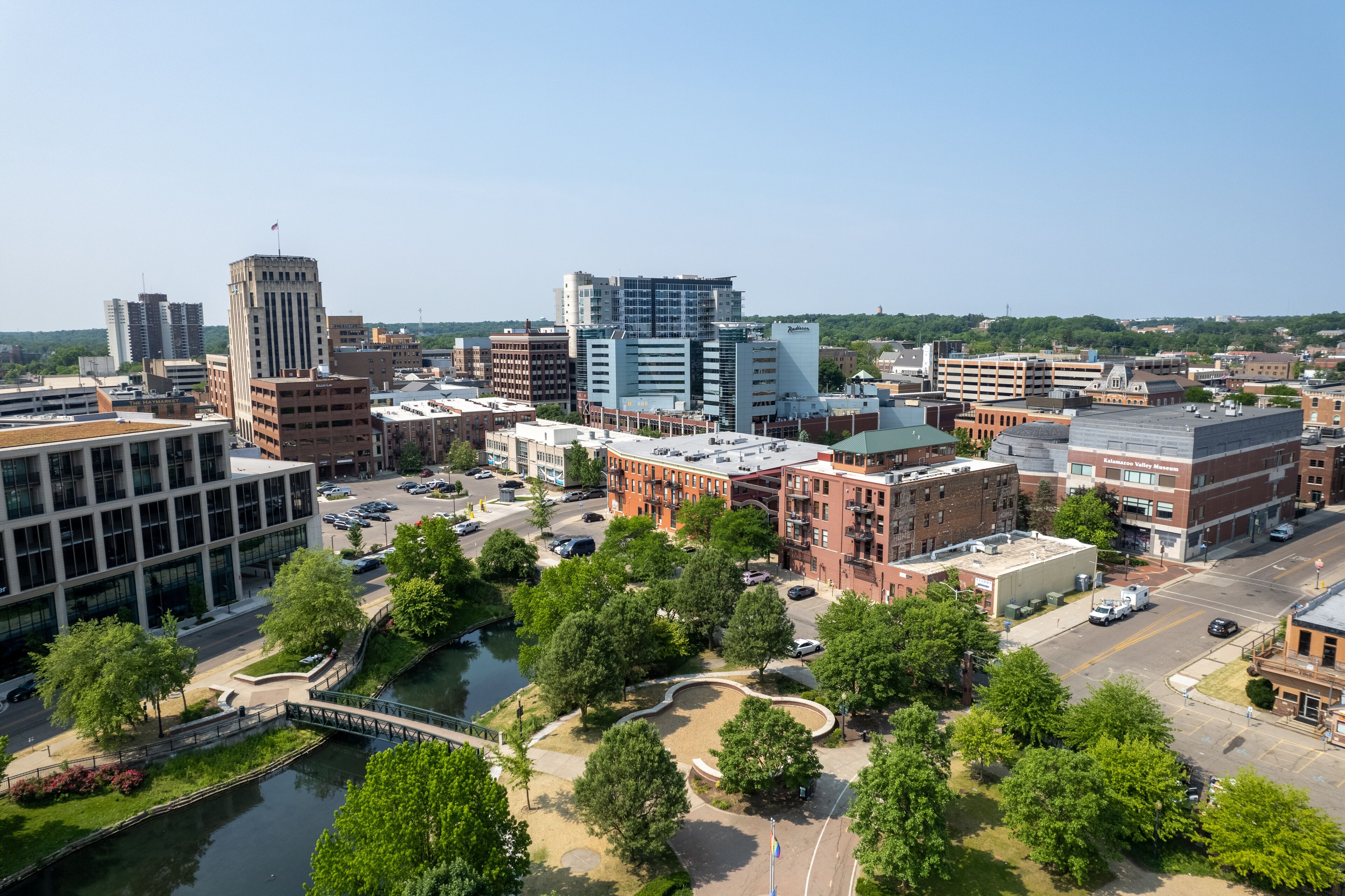 A cityscape with a mix of modern and historic buildings, a river, and a bridge.