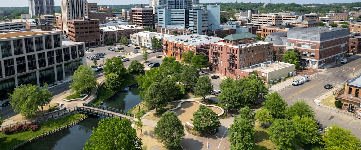 A cityscape with a mix of modern and historic buildings, a river, and a bridge.