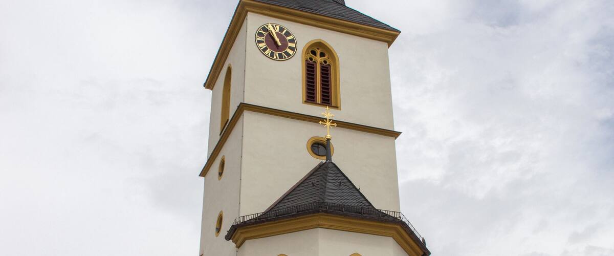 A church with a tall steeple and a clock.