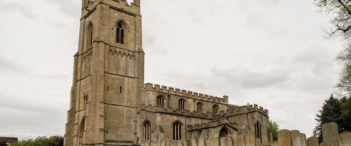 A historic church with a tall bell tower and a large arched entrance.