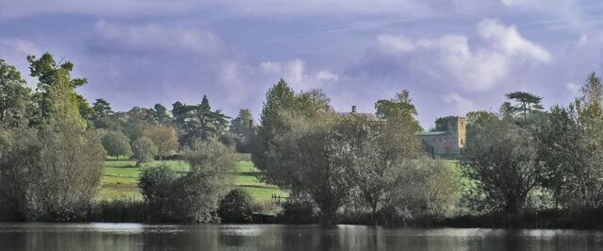 All Saints at Claydon House This view of the Church overlooks the lower lake at Claydon House. The house itself is hidden behind the trees to the left of the church.