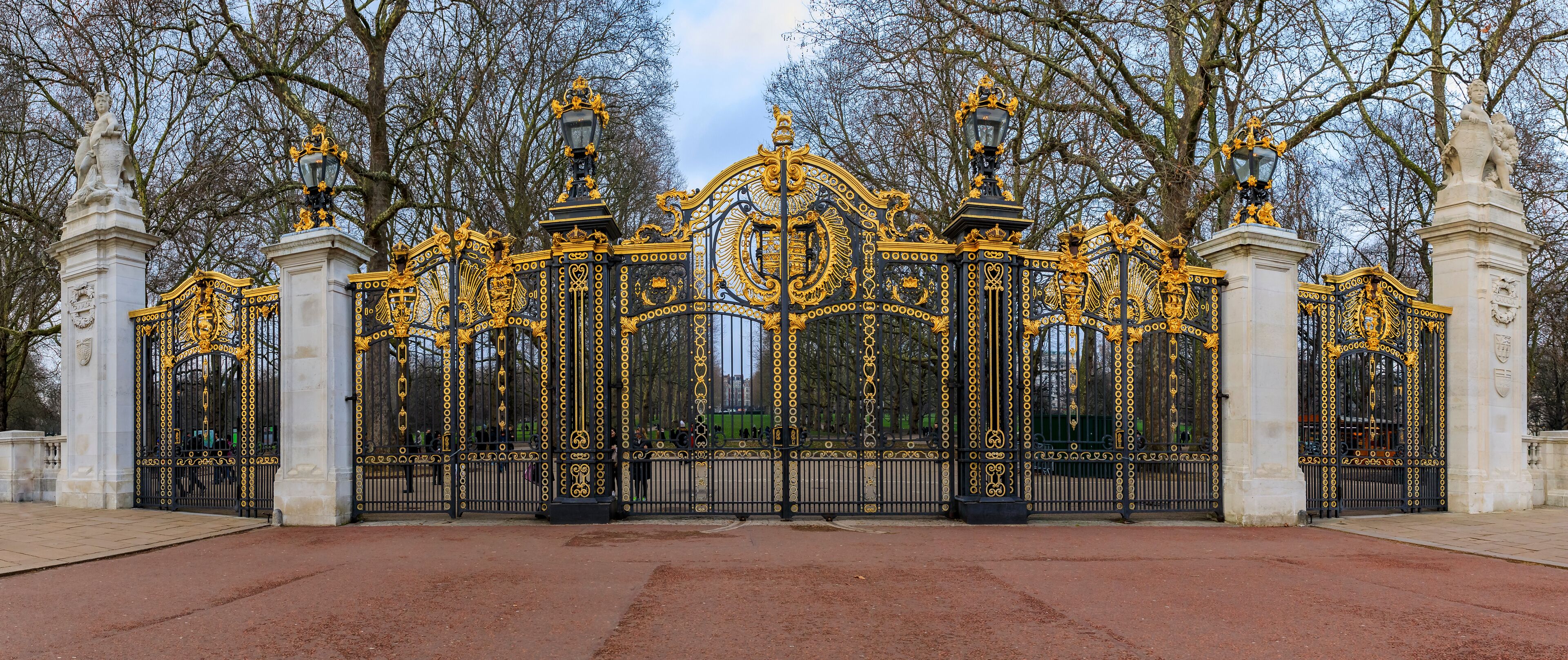An ornate black and gold gate with statues and intricate designs.