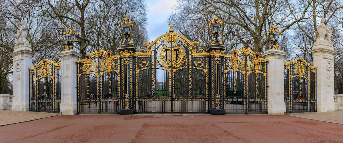 An ornate black and gold gate with statues and intricate designs.