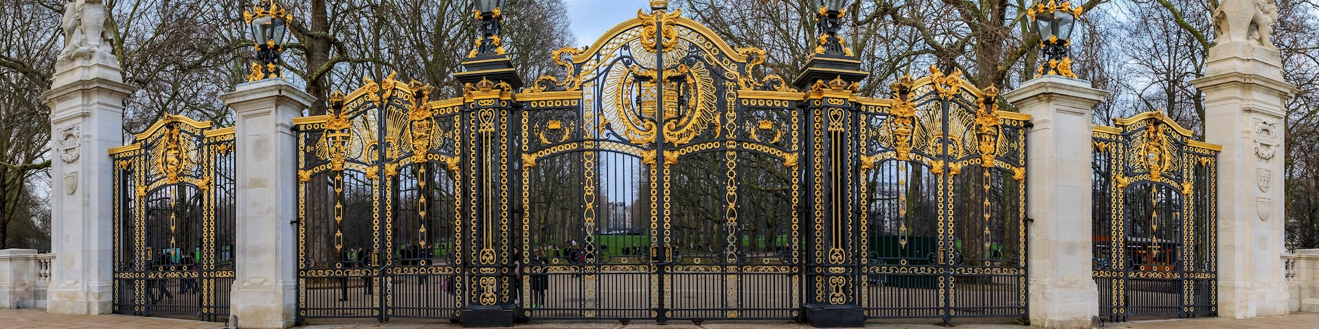 An ornate black and gold gate with statues and intricate designs.