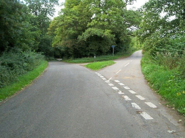 Beside Mill Copse. Road junction by Mill Copse.