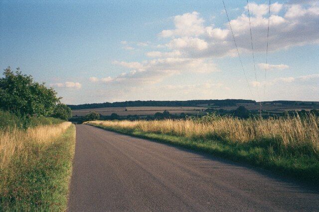 Catsham Lane. The road goes from Chadlington to the B4437, crossing the Evenlode river and the Cotswold railway line. This image faces south, with Wychwood Forest on the skyline.