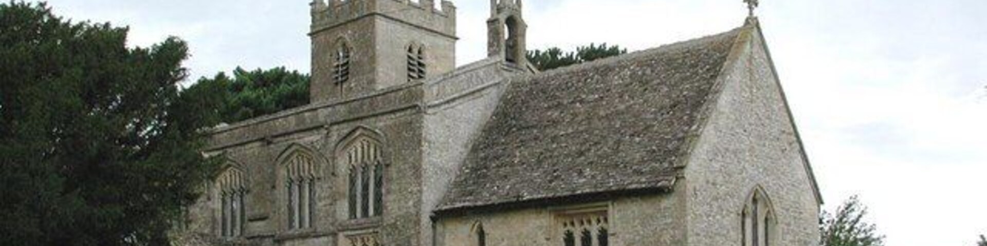 A historic stone church with a tower and arched windows.