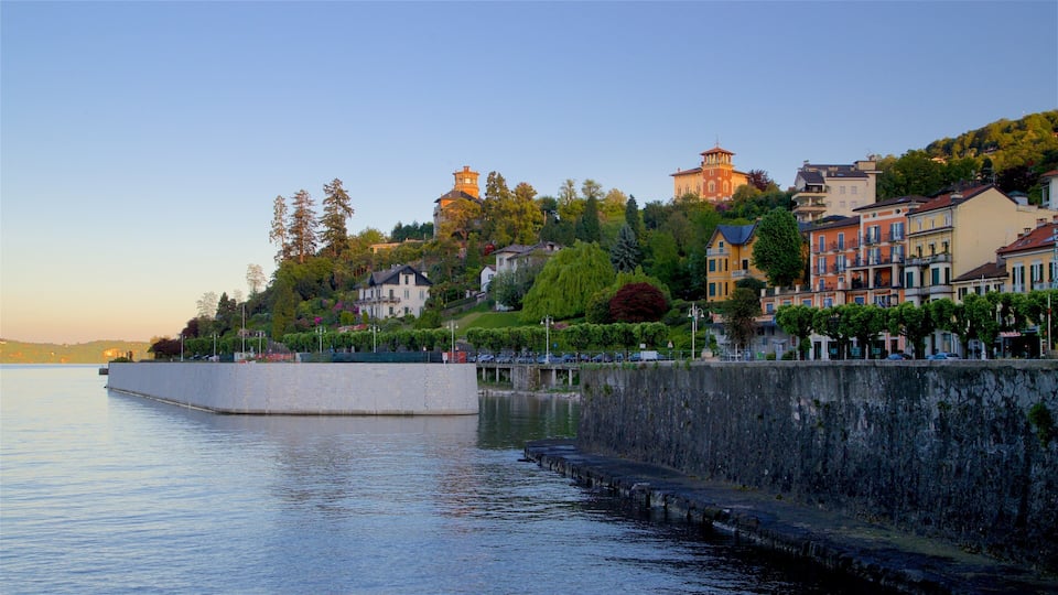 A waterfront with buildings, trees, and a stone wall.