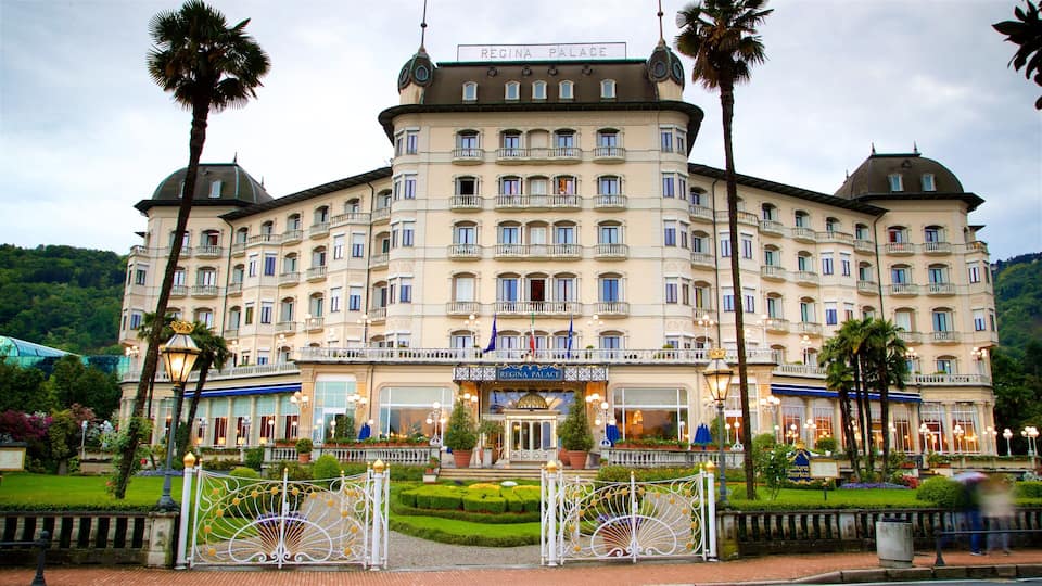 A large, ornate hotel with multiple balconies and flags, surrounded by well-manicured gardens and palm trees.