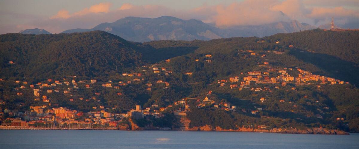 A coastal town nestled in a valley with mountains in the background.