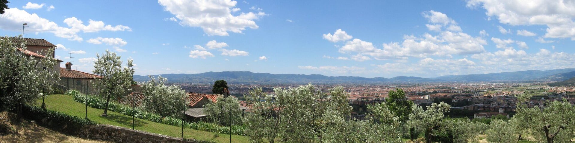 A panoramic view of a town nestled in a valley with mountains in the background.